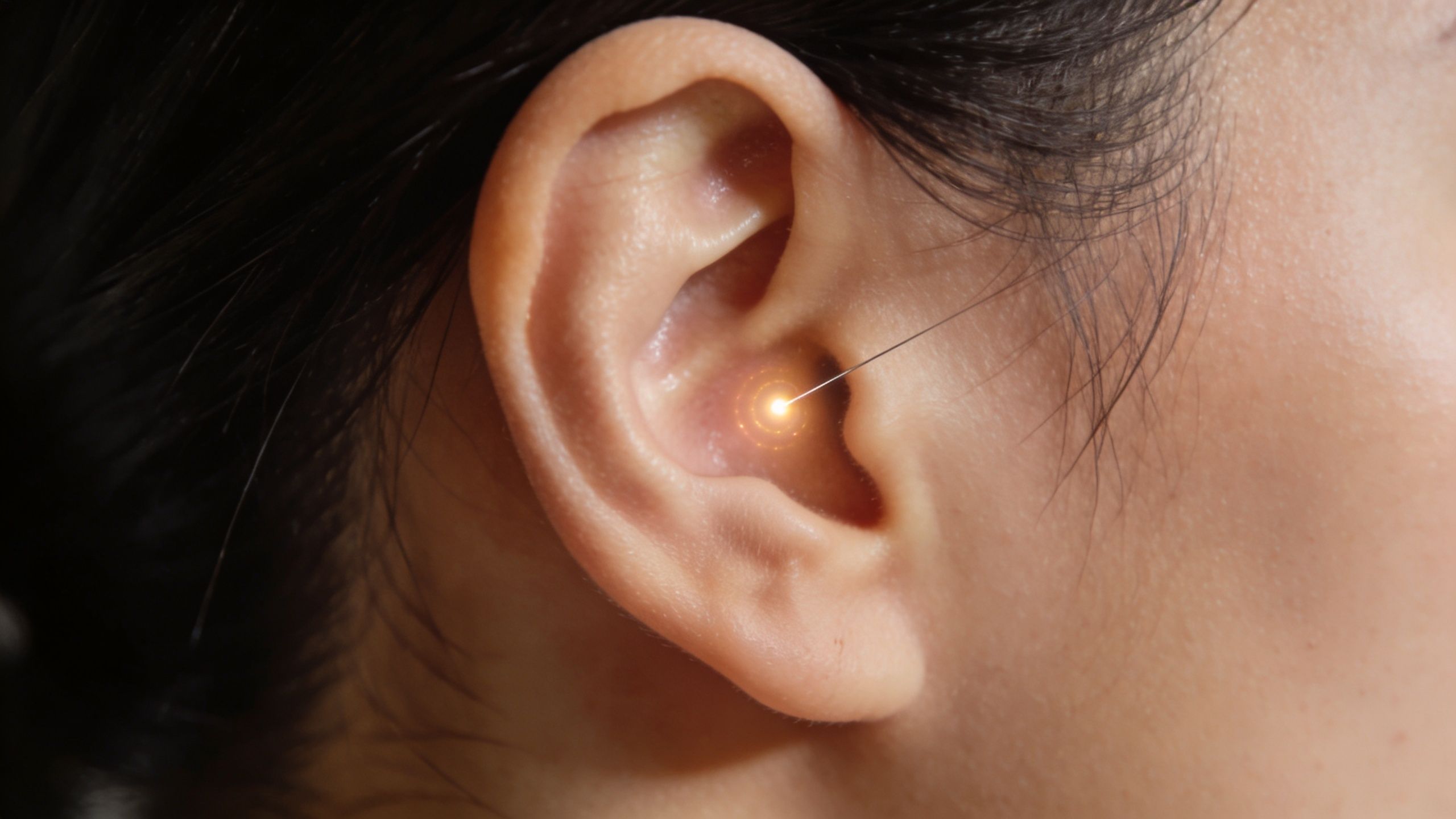 Nettoyer poumons fumeur : Notre protocole naturel 5 Vue rapprochée d'une oreille humaine avec un point lumineux focalisé, symbolisant un traitement médical ou auriculaire précis.